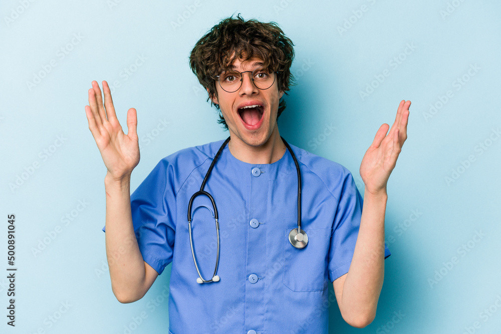 Young caucasian nurse man isolated on blue background receiving a pleasant surprise, excited and raising hands. Young caucasian nurse man isolated on blue background receiving a pleasant surprise, excited and raising hands.