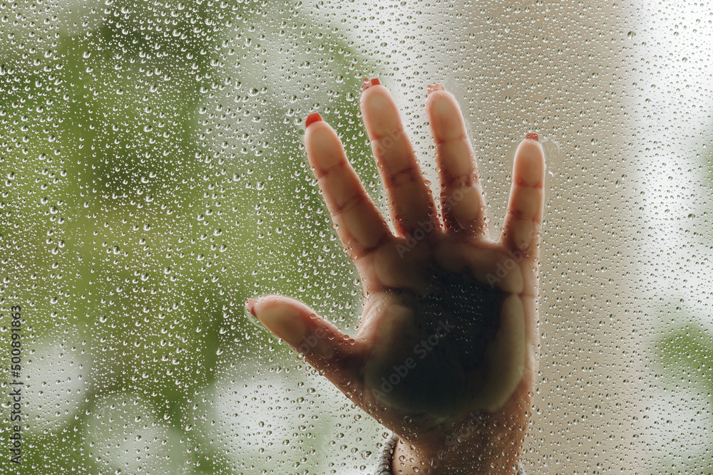 There is a closeup view on the raindrops and hand-imprint on the background. There is a closeup view on the raindrops and hand-imprint on the background.