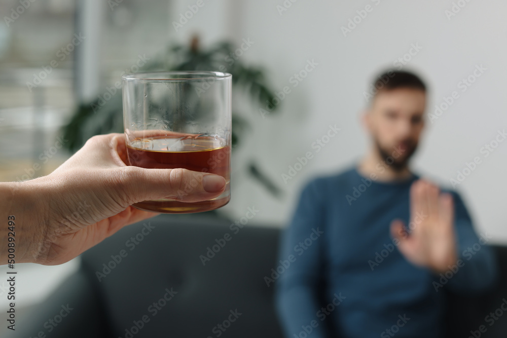 Man refusing to drink whiskey indoors, closeup. Alcohol addiction treatment Man refusing to drink whiskey indoors, closeup. Alcohol addiction treatment