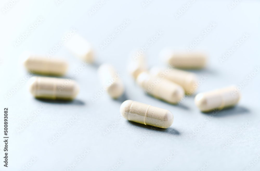  Selenium capsules. Concept for a healthy dietary supplementation. Bright paper background. Soft focus. Close up. Copy space.