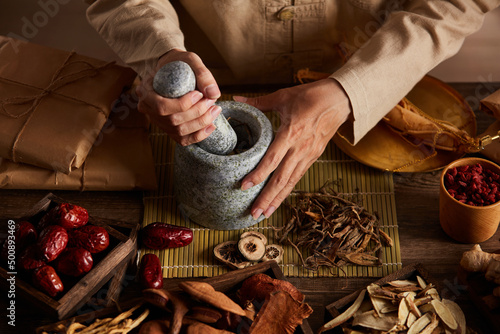 Obraz na plátně Front view of apocathery putting ingredient into mortar and pestle with chinese