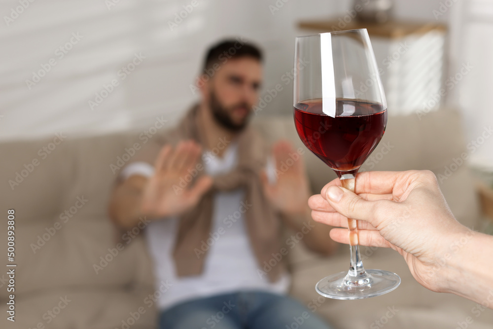 Man refusing to drink red wine indoors, closeup. Alcohol addiction Man refusing to drink red wine indoors, closeup. Alcohol addiction