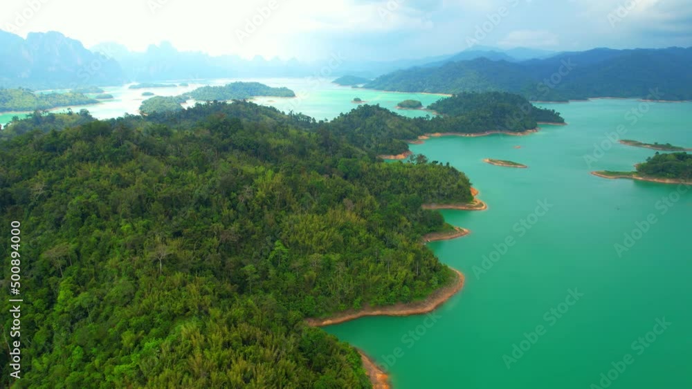 An aerial view from a drone flying over a dam, beautiful turquoise water in a valley. Many small islands and mountains in the background. Ratchaprapha dam, Surat Thani Province, Thailand. 4K
An aerial view from a drone flying over a dam, beautiful turquoise water in a valley. Many small islands and mountains in the background. Ratchaprapha dam, Surat Thani Province, Thailand. 4K