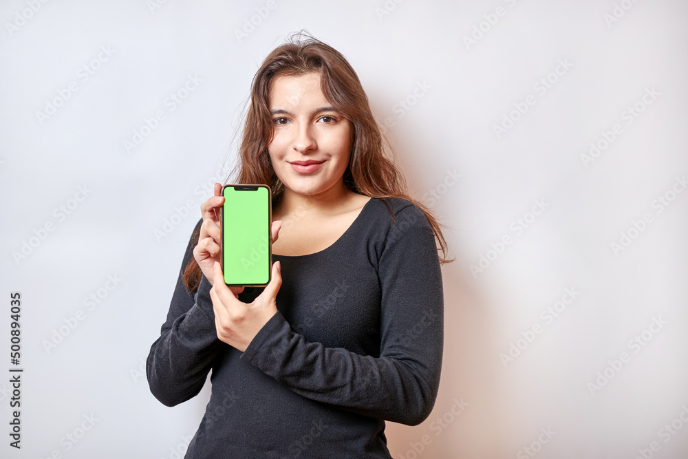 Pretty girl holding a smartphone with a green display. Pretty girl holding a smartphone with a green display.