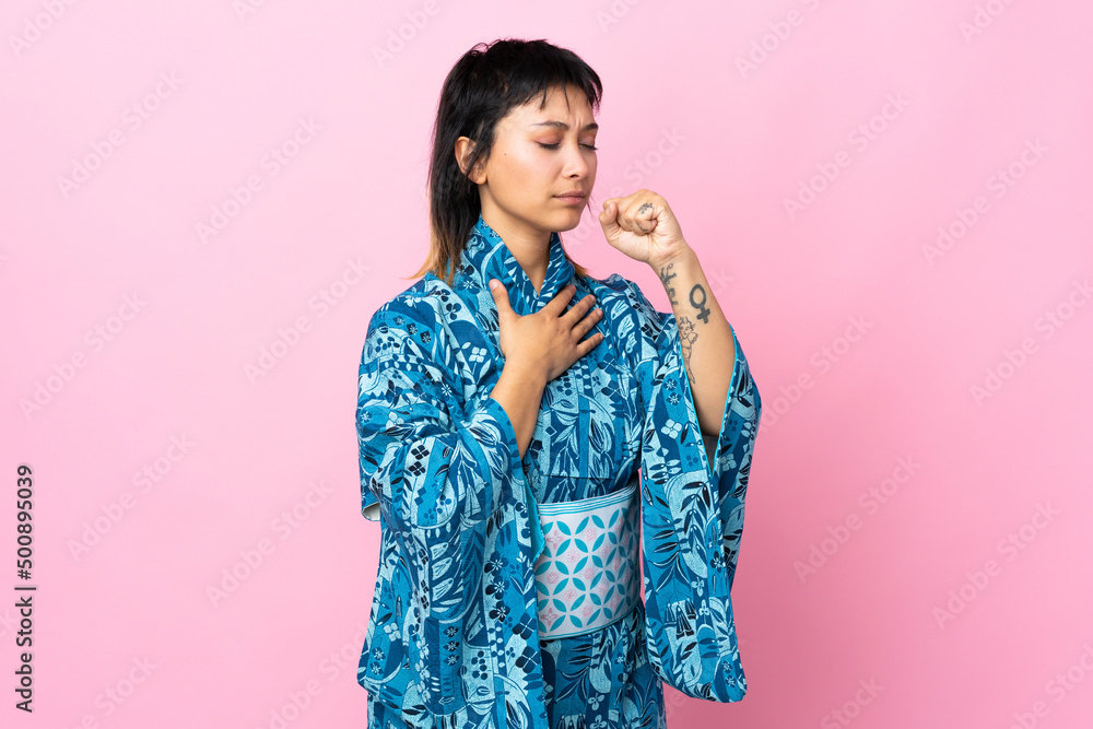 Young woman wearing kimono over isolated blue background coughing a lot Young woman wearing kimono over isolated blue background coughing a lot