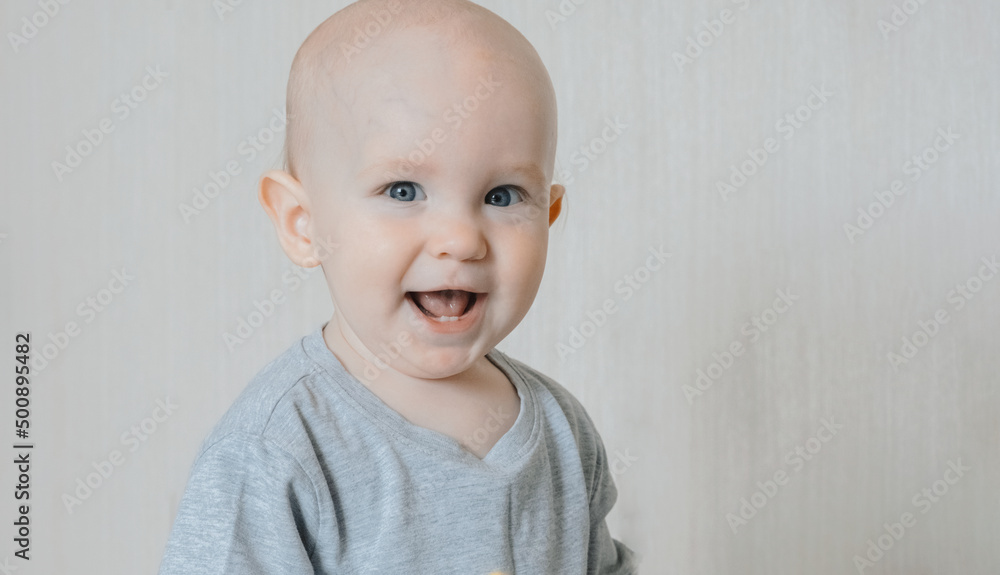 Cute small boy lying at bed. Childhood concept. Light background. Smiling child. Happy emotion. Copyspace. Horizontal banner Cute small boy lying at bed. Childhood concept. Light background. Smiling child. Happy emotion. Copyspace. Horizontal banner
