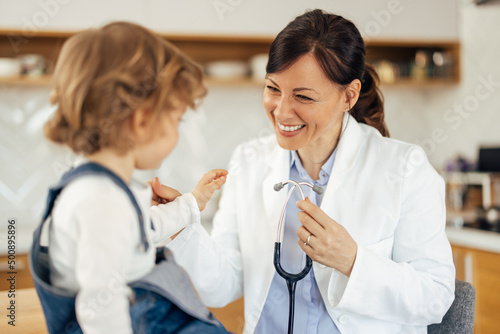 Fotografie A smiling female pediatrician has an appointment with a male tod