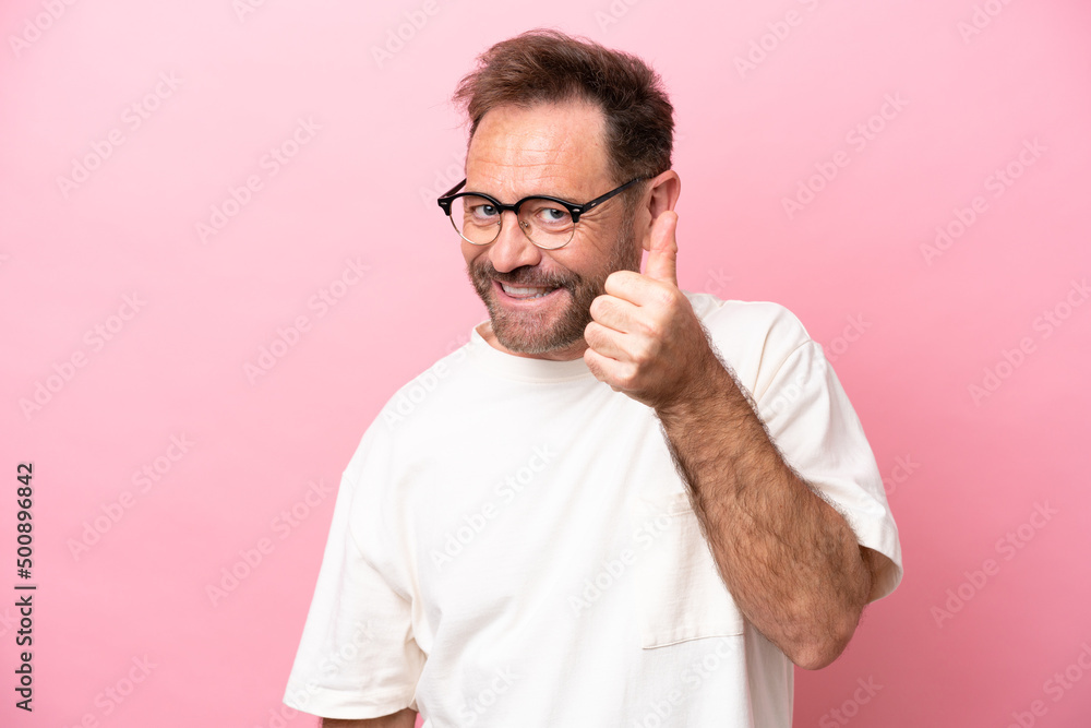 Middle age caucasian man isolated on pink background With glasses and with thumb up Middle age caucasian man isolated on pink background With glasses and with thumb up