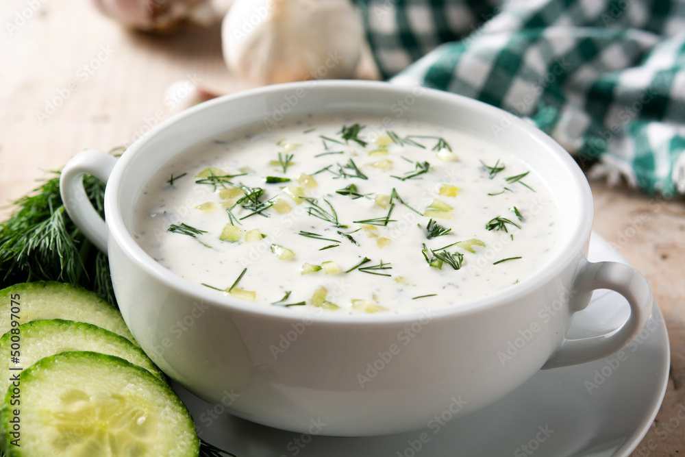 Bulgarian tarator sour milk soup in bowl on wooden table Bulgarian tarator sour milk soup in bowl on wooden table