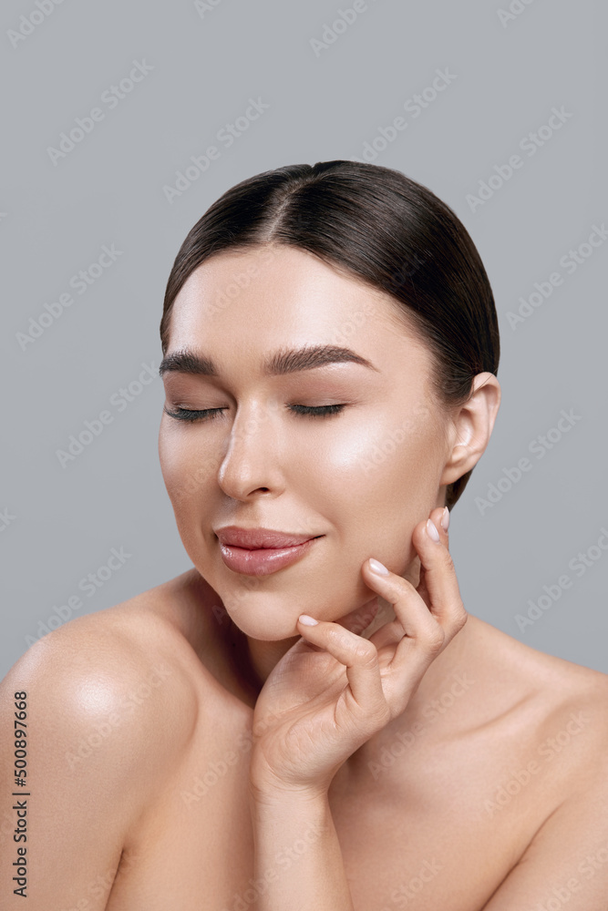 Beauty face. Woman with natural makeup and healthy skin portrait. Beautiful girl model touching fresh facial skin on grey background closeup. Skin care concept Beauty face. Woman with natural makeup and healthy skin portrait. Beautiful girl model touching fresh facial skin on grey background closeup. Skin care concept