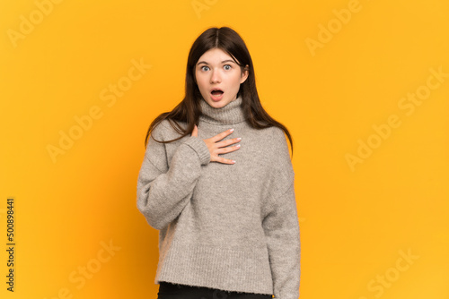 Young Ukrainian girl isolated on yellow background surprised and shocked while looking right © luismolinero