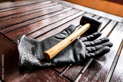  Worker in his work area with a computer, gloves and a mallet hammer