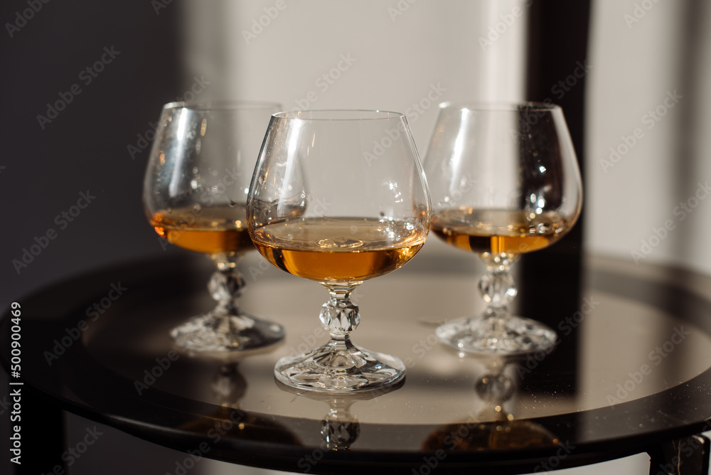 Three glasses with whiskey on the table Three glasses with whiskey on the table