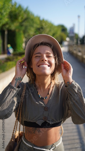 Close portrait of a smiling hippie girl. A charming girl with freckles in a hat smiles and laughs merrily. Bright and beautiful smile