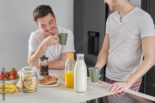 Wallpaper Mural Young gay couple having breakfast, talking and laughing. Morning routine. Torontodigital.ca
