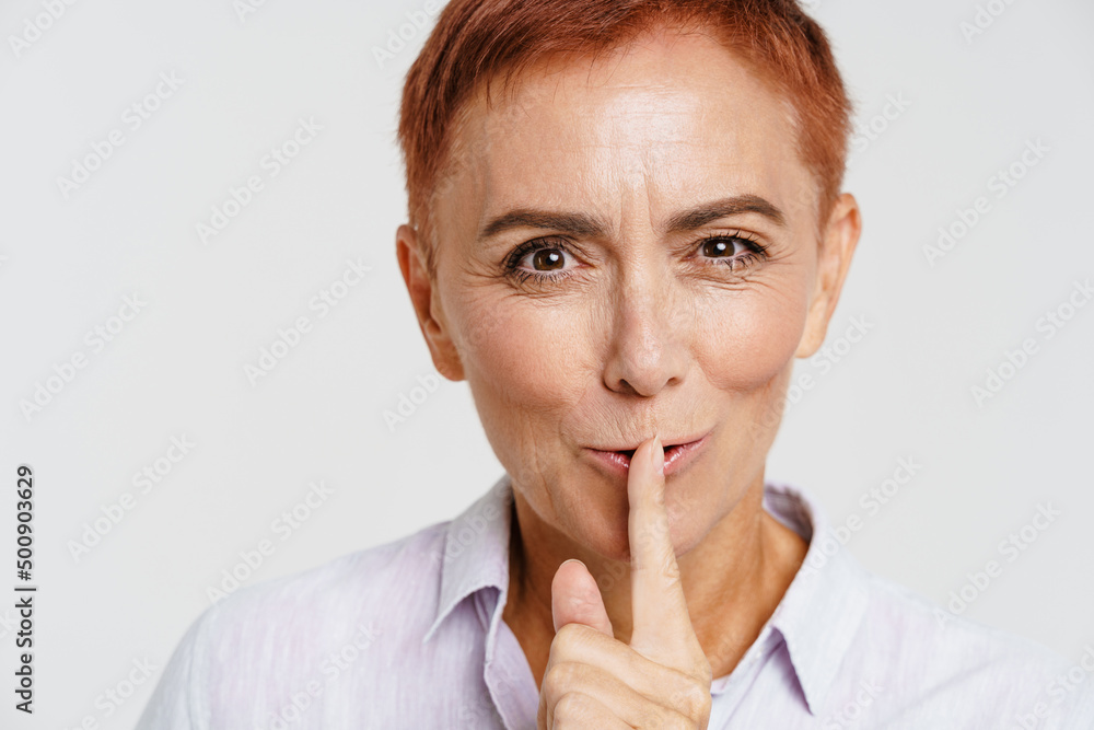 Ginger senior woman with short hair showing silence gesture Ginger senior woman with short hair showing silence gesture