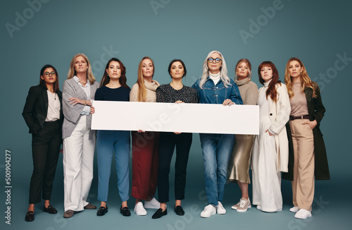 Feminist activists holding a white banner in a studio photo