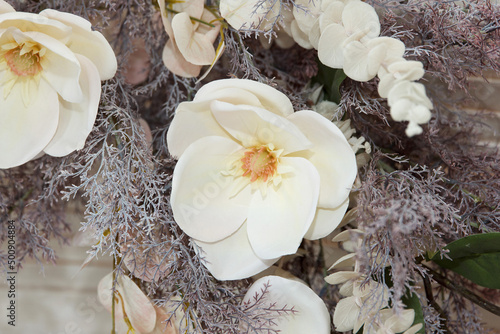 Bouquet of lovely big white ornamental flower made of material and plastic hanging, as part of interior photo