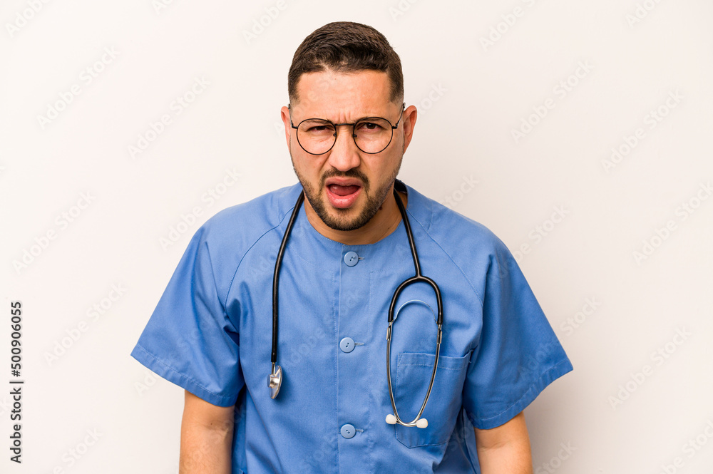 Hispanic nurse man isolated on white background screaming very angry and aggressive. Hispanic nurse man isolated on white background screaming very angry and aggressive.