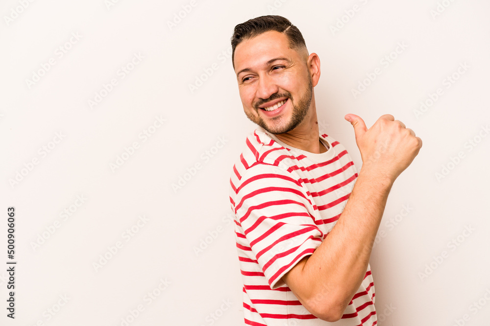Young hispanic man isolated on white background points with thumb finger away, laughing and carefree. Young hispanic man isolated on white background points with thumb finger away, laughing and carefree.