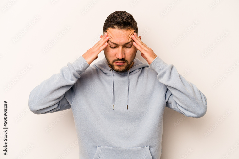 Young hispanic man isolated on white background touching temples and having headache. Young hispanic man isolated on white background touching temples and having headache.
