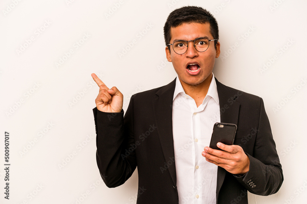 Young business hispanic man holding mobile phone isolated on white background pointing to the side Young business hispanic man holding mobile phone isolated on white background pointing to the side