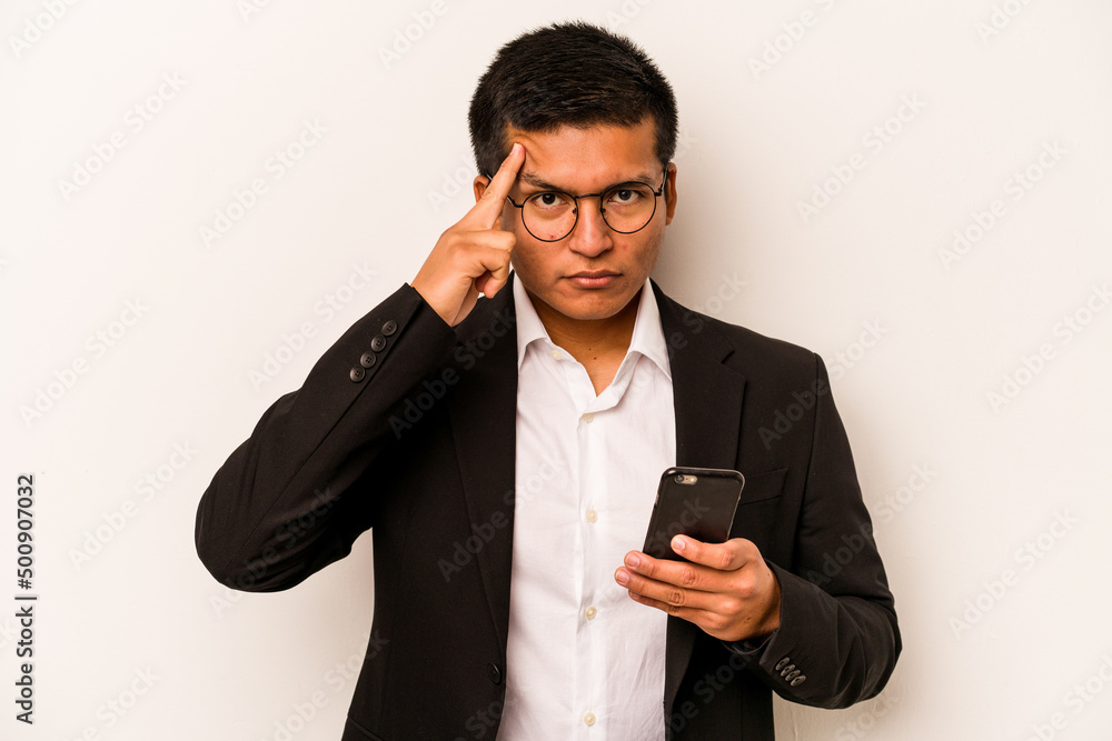 Young business hispanic man holding mobile phone isolated on white background pointing temple with finger, thinking, focused on a task. Young business hispanic man holding mobile phone isolated on white background pointing temple with finger, thinking, focused on a task.