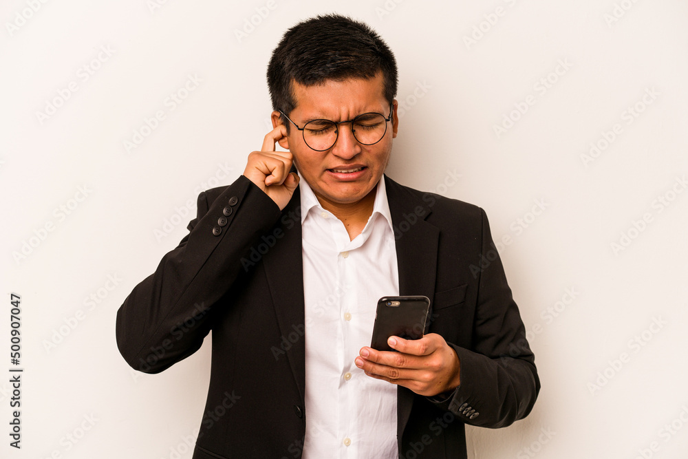 Young business hispanic man holding mobile phone isolated on white background covering ears with hands. Young business hispanic man holding mobile phone isolated on white background covering ears with hands.