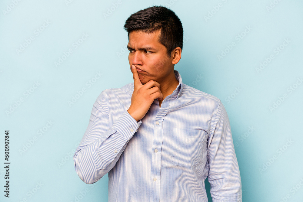Young hispanic man isolated on blue background keeping a secret or asking for silence. Young hispanic man isolated on blue background keeping a secret or asking for silence.