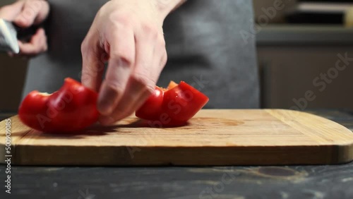 person slicing bell pepper with a knife