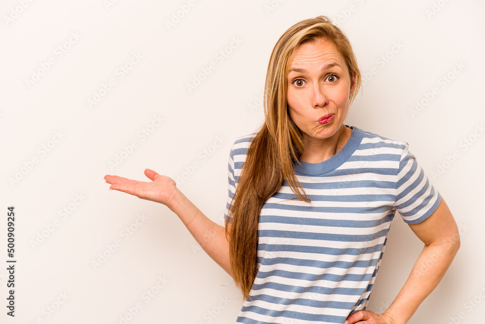 Young caucasian woman isolated on white background showing a copy space on a palm and holding another hand on waist. Young caucasian woman isolated on white background showing a copy space on a palm and holding another hand on waist.