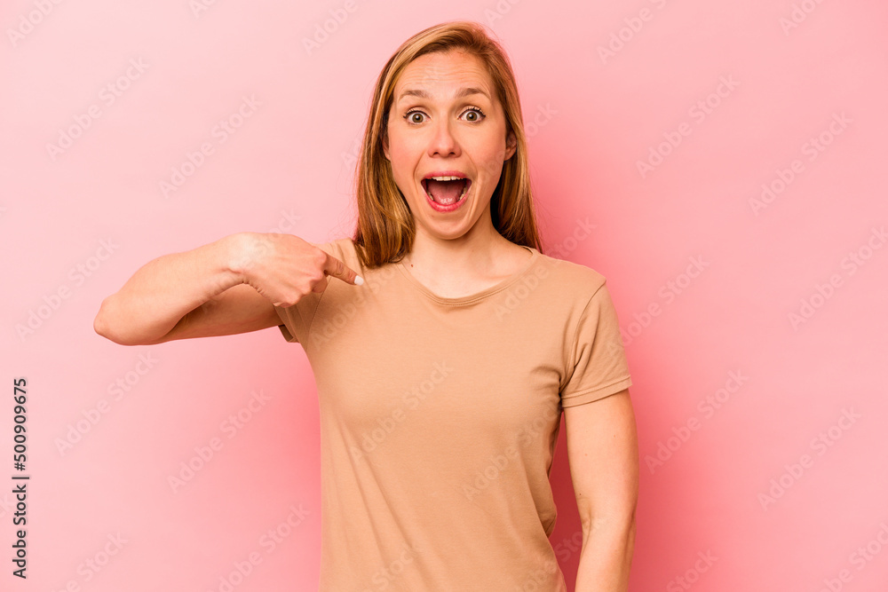 Young caucasian woman isolated on pink background surprised pointing with finger, smiling broadly. Young caucasian woman isolated on pink background surprised pointing with finger, smiling broadly.