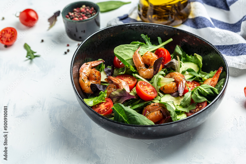 Fresh salad bowl with smoked shrimps, cherry tomatoes, cucumber and mixed leaves, Healthy food. Clean eating. top view