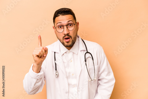 Hispanic doctor man isolated on beige background having an idea, inspiration concept. © Asier