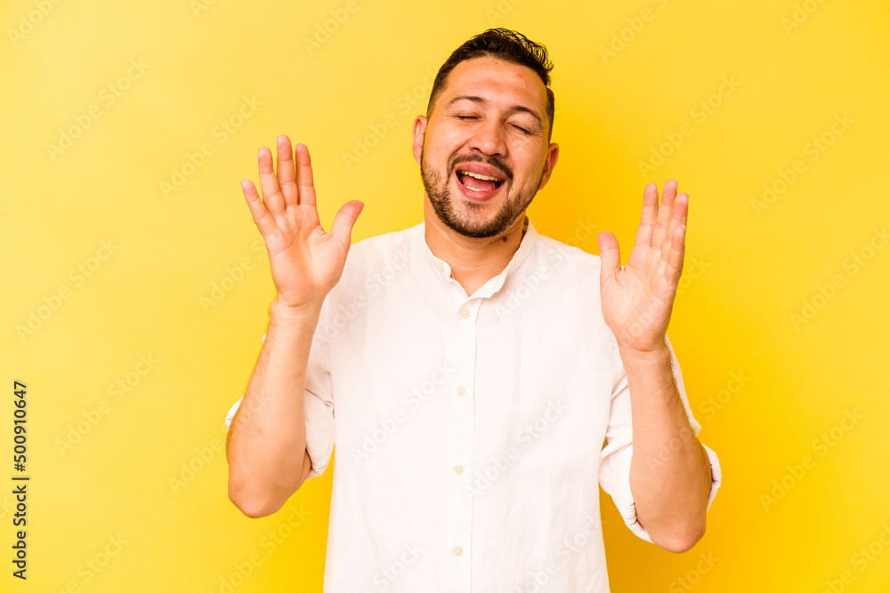 Young hispanic man isolated on yellow background laughs out loudly keeping hand on chest. Young hispanic man isolated on yellow background laughs out loudly keeping hand on chest.