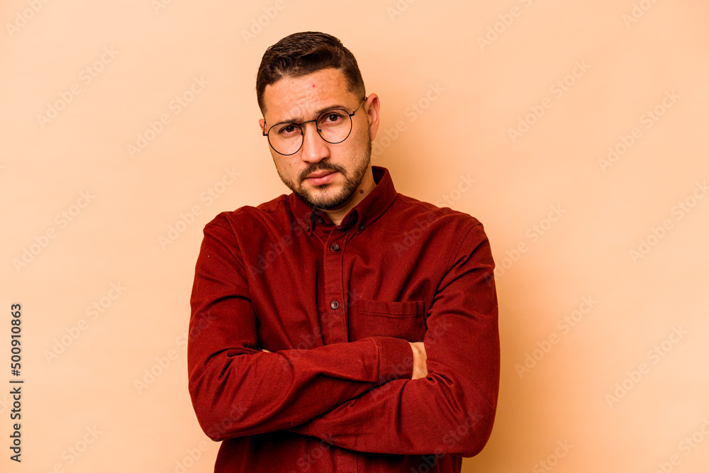 Young hispanic man isolated on beige background unhappy looking in camera with sarcastic expression. Young hispanic man isolated on beige background unhappy looking in camera with sarcastic expression.