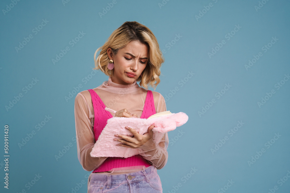 Young white woman writing down notes in stuffed exercise book Young white woman writing down notes in stuffed exercise book