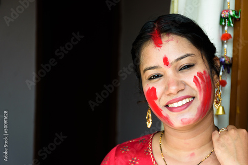 Happy young Bengali woman celebrates Sindur Khela tradition in Durga puja festival. Durga puja festival is one of the biggest festival in India photo