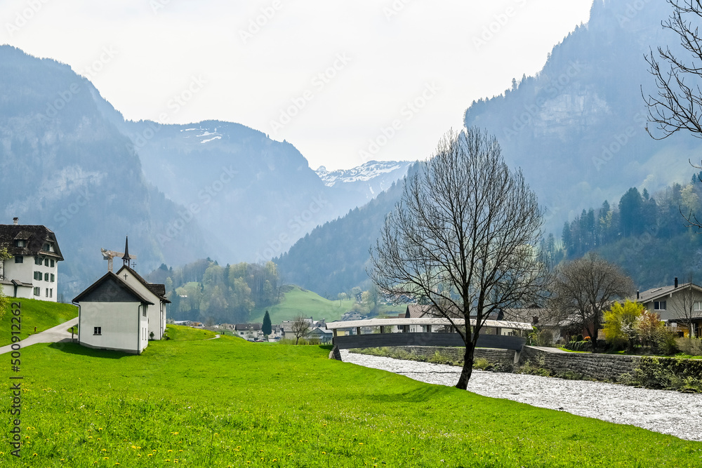 Obraz premium Muotathal, Dorf, Wanderweg, Muota, Fluss, Muotatal, Kirche, Kapelle, Kloster, Bergtal, Alpen, Pragelpass, Frühling, Schweiz