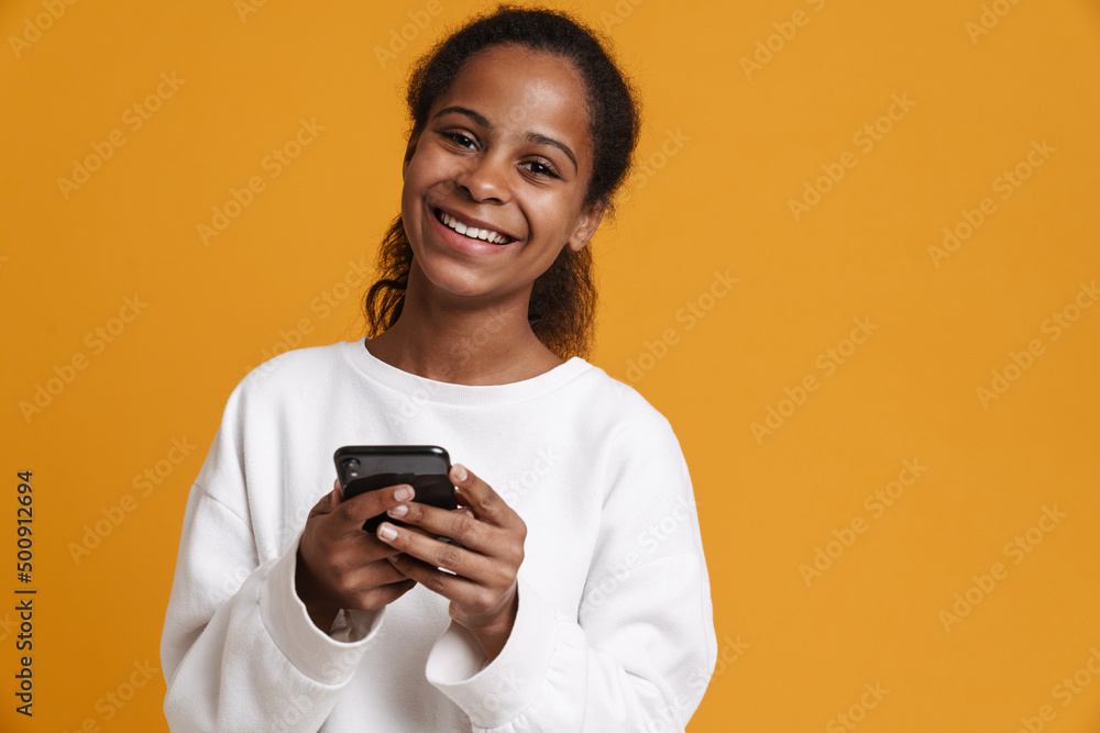 Brunette black girl smiling while using cellphone Brunette black girl smiling while using cellphone