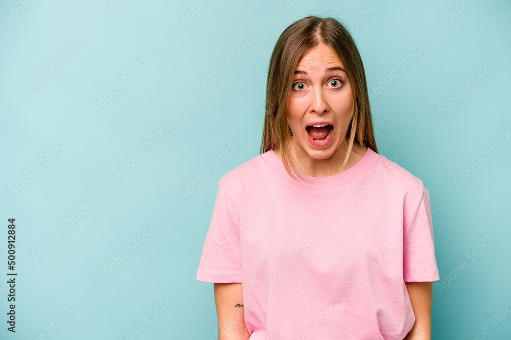 Young caucasian woman isolated on blue background shouting very angry, rage concept, frustrated. Young caucasian woman isolated on blue background shouting very angry, rage concept, frustrated.