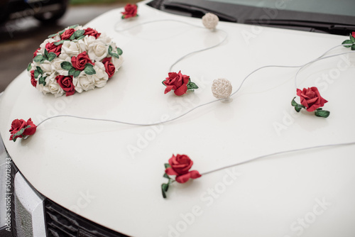 Fotografie White car in a wedding procession beautifully decorated with flowers