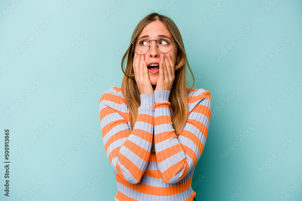 Young caucasian woman isolated on blue background scared and afraid. Young caucasian woman isolated on blue background scared and afraid.