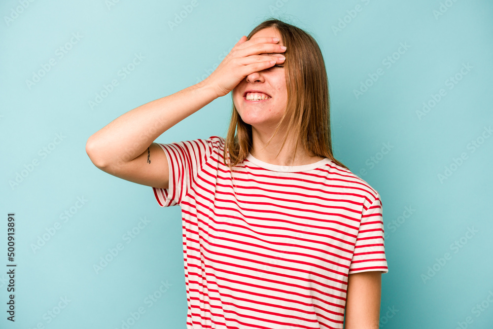 Young caucasian woman isolated on blue background laughs joyfully keeping hands on head. Happiness concept. Young caucasian woman isolated on blue background laughs joyfully keeping hands on head. Happiness concept.