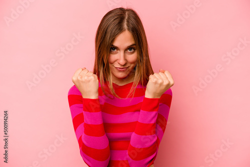 Young caucasian woman isolated on pink background upset screaming with tense hands.