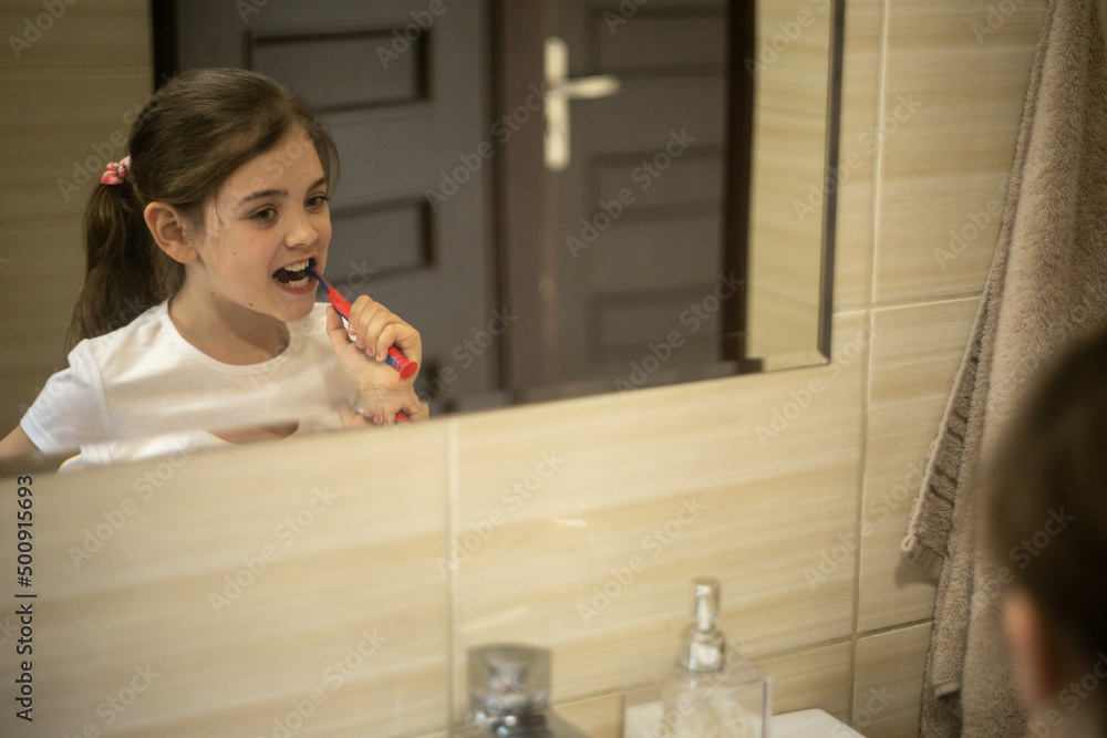 Dziewczynka myjąca swoje zęby przed lustrem - obrazy, fototapety, plakaty 
