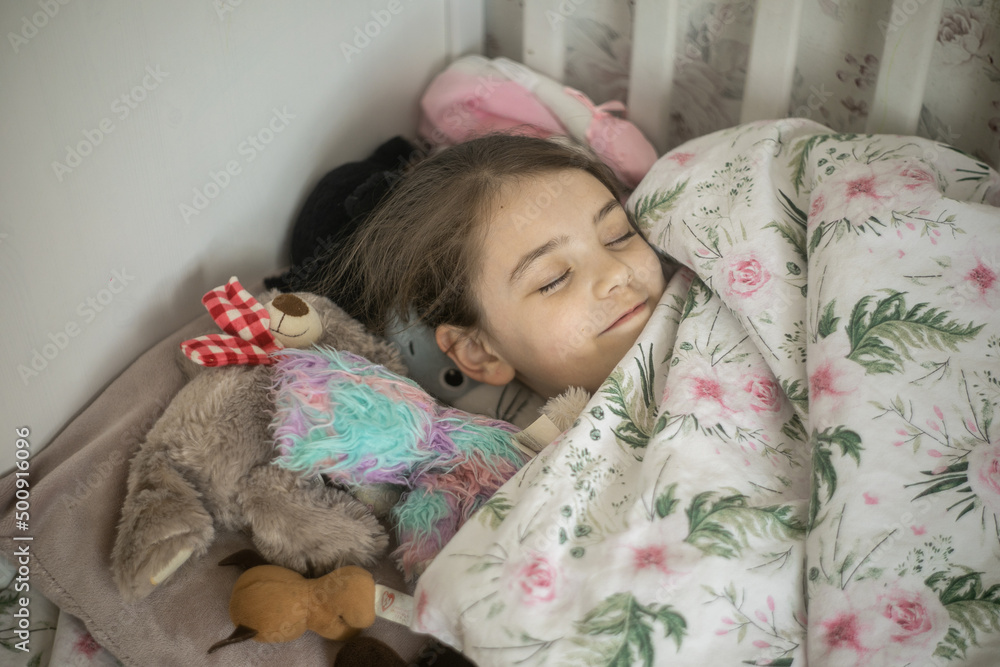 Młoda dziewczynka śpiąca w swoim łóżku - obrazy, fototapety, plakaty 