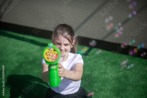 Dziewczynka celująca z pistoletu na bańki