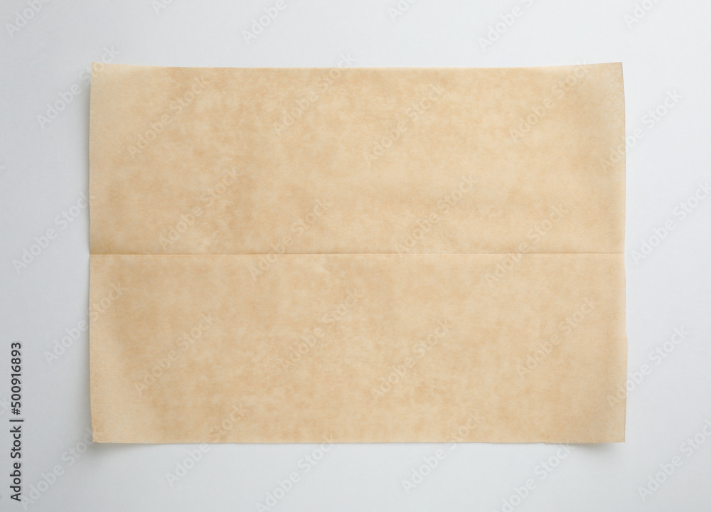 Sheet of brown baking paper on white background, top view Sheet of brown baking paper on white background, top view