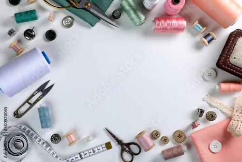 Different sewing accessories on white background, top view. Space for text